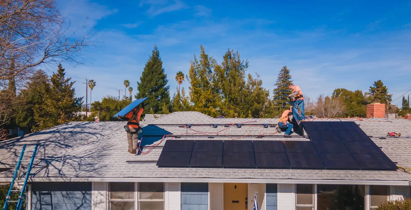 Aerial view of Westhaven installers laying black solar panels across a Nor-Cal roof.