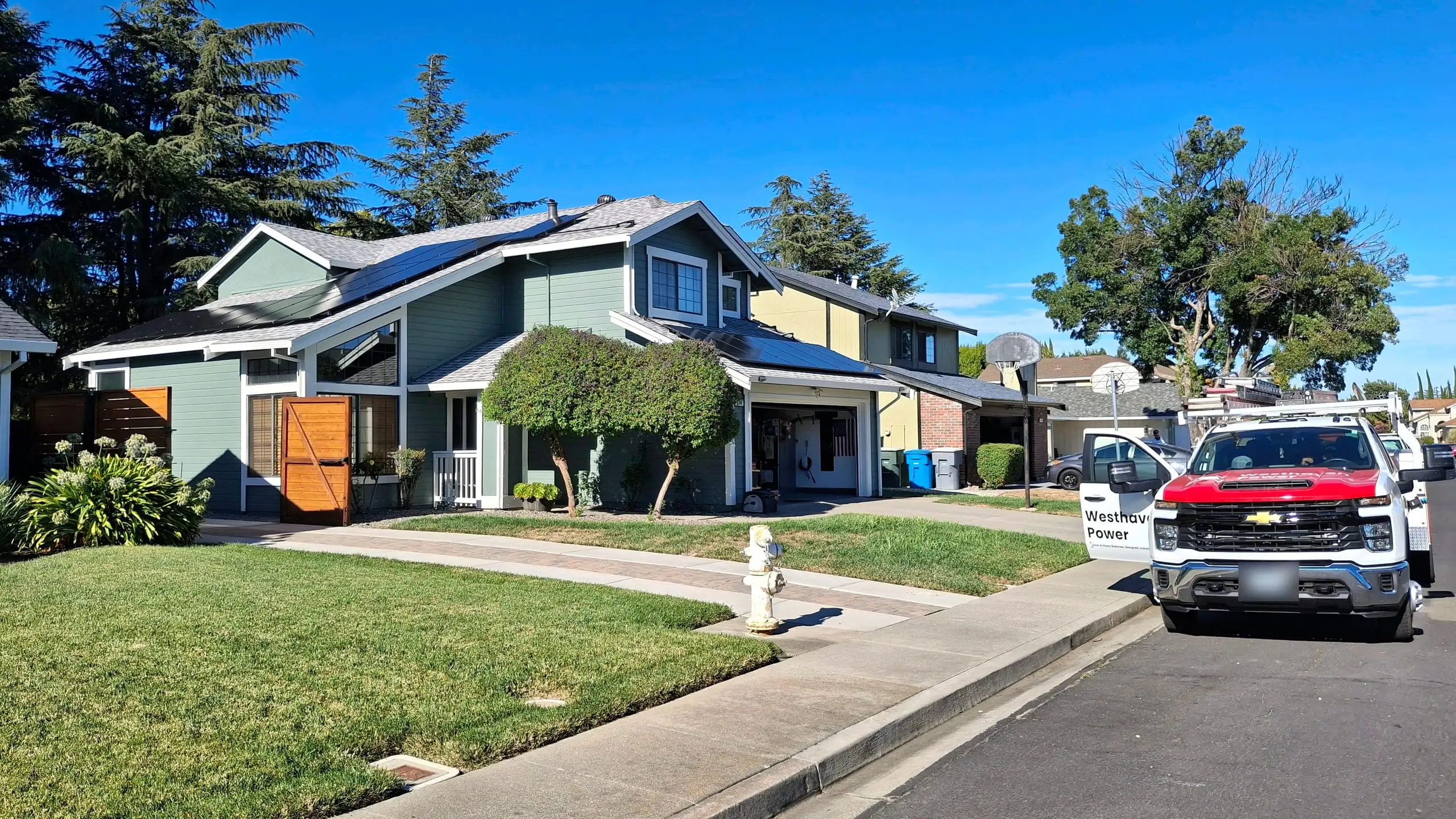 A completed Westhaven solar installation with service trucks parked out front.
