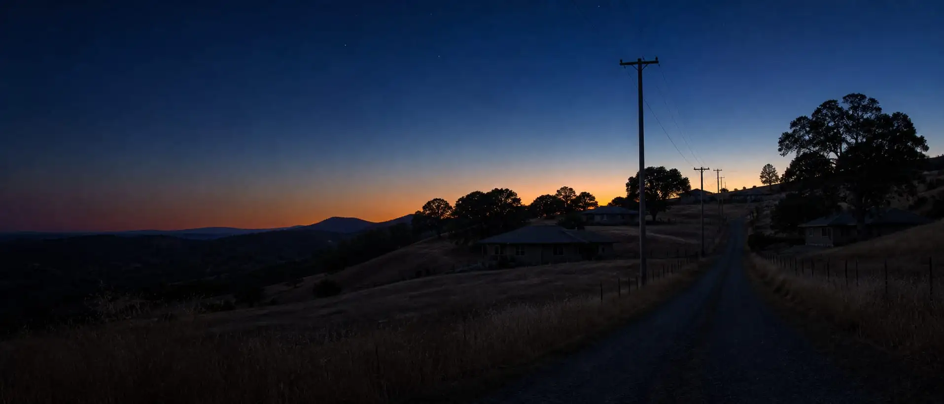 A rural Northern California neighborhood sits dark at dusk during a planned power shutoff.